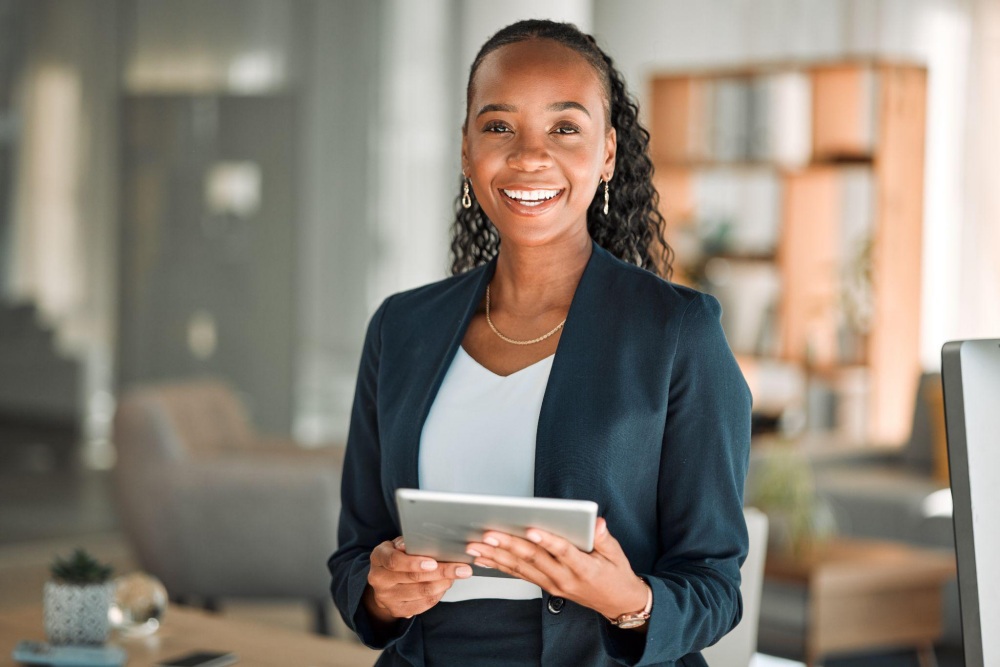 Smiling businesswoman holding tablet in office