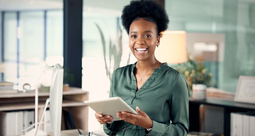 Smiling professional woman holding tablet in modern office
