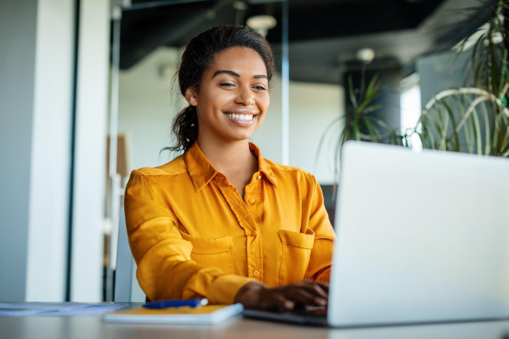 Smiling professional woman working on laptop in modern office