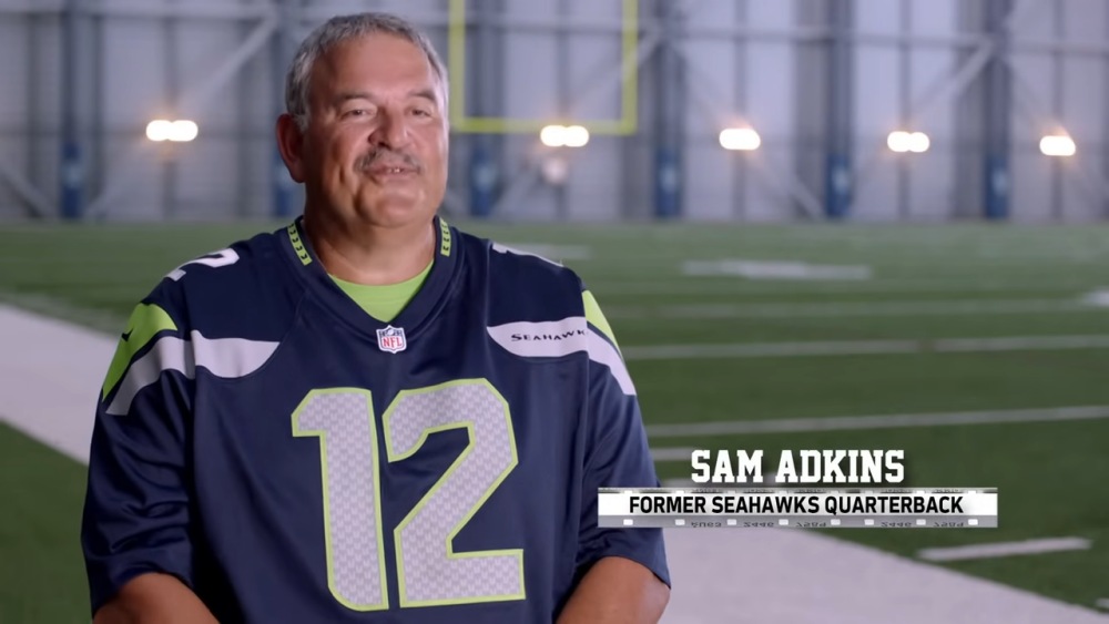 Sam Adkins, former Seahawks quarterback, wearing #12 jersey indoors.